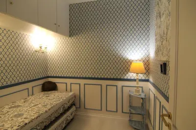 a bedroom with a bed and a lamp on a wall at La Reale in Villefranche-sur-Mer