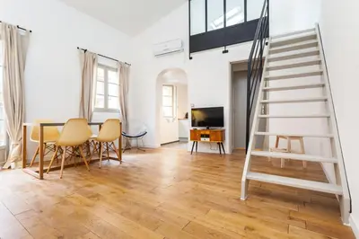a living room with a staircase and a table and chairs at Malonat Duplex - Old Town in Nice