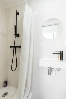 a white bathroom with a shower curtain and a sink at Malonat Duplex - Old Town in Nice