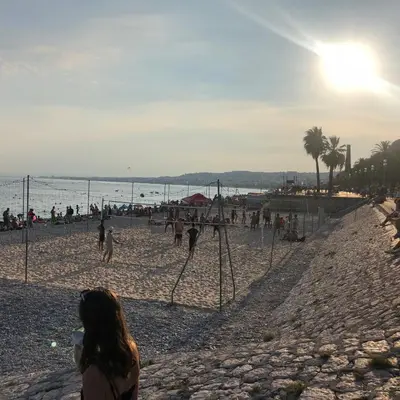a group of people walking on a beach at Moulin -Old Town in Nice