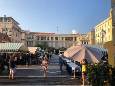a group of people walking around a market with umbrellas at Moulin -Old Town in Nice