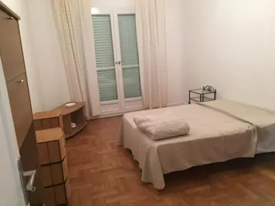 a bedroom with a bed and a dresser and two windows at Le Palais Martine in Nice