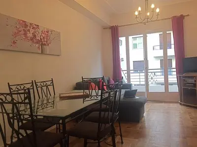 a living room with a dining room table and chairs at Le Palais Martine in Nice