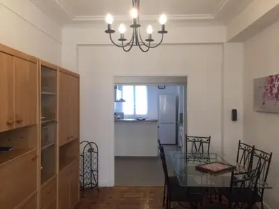 a dining room and kitchen with a glass table and chairs at Le Palais Martine in Nice
