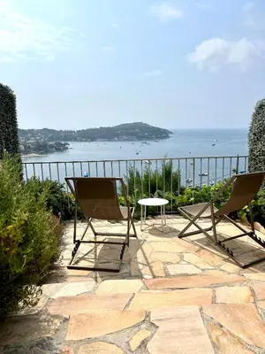 two chairs and a table on a patio overlooking the ocean at Studio Leopolda in Villefranche-sur-Mer