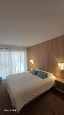 a bedroom with two beds and a blue chair at Residence Club Inn in Nice