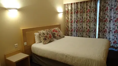a hotel room with a bed with two pillows at Residence Club Inn in Nice