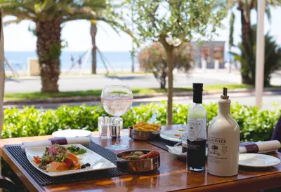 a table with a plate of food and a bottle of wine at Westminster Hotel & Spa Nice in Nice