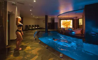a woman standing next to a swimming pool in a hotel at Westminster Hotel & Spa Nice in Nice