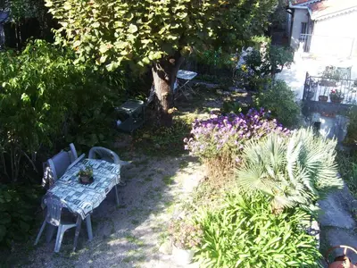 a garden with a table and chairs and flowers at Les lilas blancs in Villefranche-sur-Mer