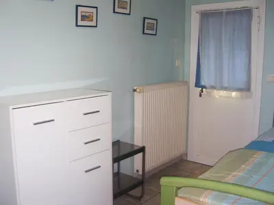a bedroom with a white dresser and a bed at Les lilas blancs in Villefranche-sur-Mer