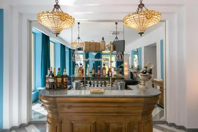a bar in a room with two chandeliers at The Jay Hotel by HappyCulture in Nice