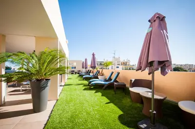 a balcony with chairs and an umbrella and grass at Residhome Nice Promenade in Nice