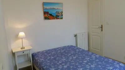 a small bedroom with a bed and a picture on the wall at Palais Rialto in Nice