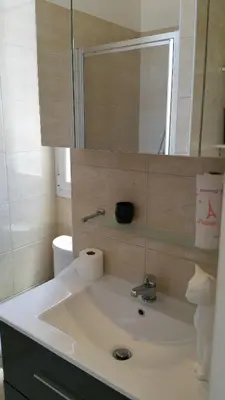 a bathroom with a sink with a mirror and a toilet at Palais Rialto in Nice