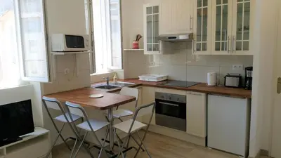 a kitchen with a small table and chairs in it at Palais Rialto in Nice