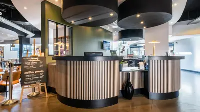 a fast food restaurant with two counters and a table at Campanile PRIME - Nice Airport in Nice