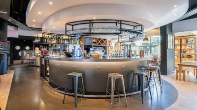 a bar in a restaurant with stools at Campanile PRIME - Nice Airport in Nice