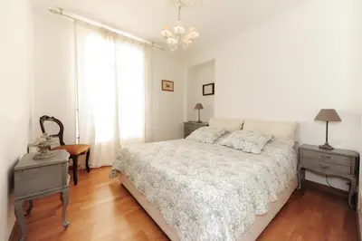 a white bedroom with a bed and a chandelier at Appartement Clemenceau Centre Nice Five stars Holiday House in Nice