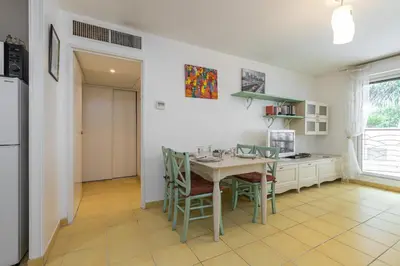 a kitchen with a table and chairs and a refrigerator at Nice 1 Bedroom downtown Carré d'Or with garage in Nice