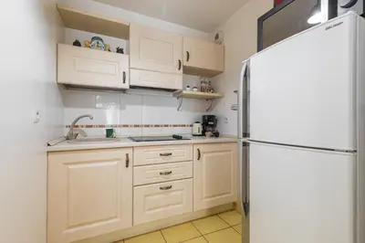 a kitchen with white cabinets and a refrigerator at Nice 1 Bedroom downtown Carré d'Or with garage in Nice