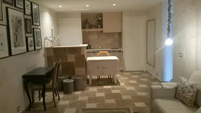 a living room with a table and a kitchen at La maison de lulu in Nice
