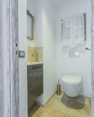 a white bathroom with a toilet and a sink at La maison de lulu in Nice