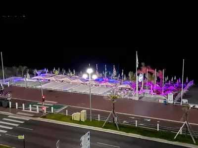 a large building with purple lights at night at LE MIRAGE, SEA FRONT view, 3 bedrooms, 100m in Nice