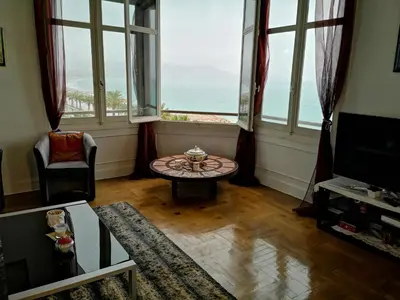 a living room with large windows and a table at LE MIRAGE, SEA FRONT view, 3 bedrooms, 100m in Nice