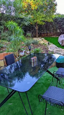 a glass table with chairs on the grass at Saint Jean Cap Ferrat in Saint-Jean-Cap-Ferrat