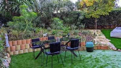a table and four chairs in a garden at Saint Jean Cap Ferrat in Saint-Jean-Cap-Ferrat