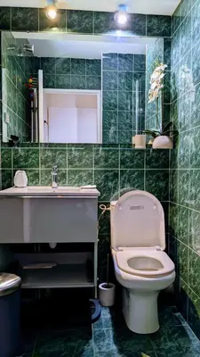 a green tiled bathroom with a toilet and a sink at Saint Jean Cap Ferrat in Saint-Jean-Cap-Ferrat