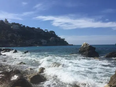 a beach with rocks and the ocean and a mountain at Chambre calme centre Nice labellisée in Nice