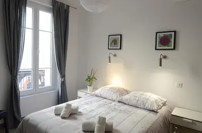 a white bedroom with a bed and a window at Carré d'or Very nice appart Near the beach in Nice
