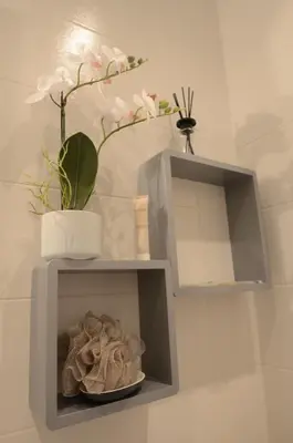a gray shelf with a plant and flowers on it at Carré d'or Very nice appart Near the beach in Nice