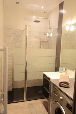 a bathroom with a shower and a washing machine at Carré d'or Very nice appart Near the beach in Nice