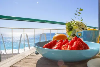 a bowl of strawberries and oranges on a table with the beach at MY CASA - PROM 13 - Sea View - Promenade des Anglais - Terrace in Nice