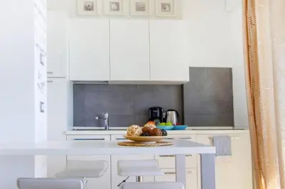 a white kitchen with a bowl of fruit on a counter at MY CASA - PROM 13 - Sea View - Promenade des Anglais - Terrace in Nice