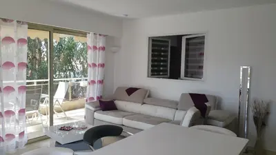 a living room with a couch and a table at Roc et Galets in Saint-Laurent-du-Var