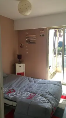 a large bed in a room with a window at Roc et Galets in Saint-Laurent-du-Var