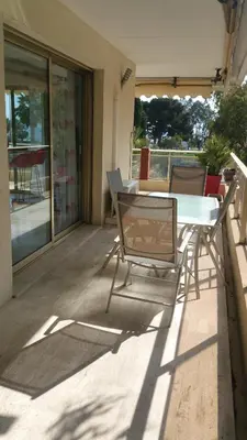 a patio with a table and chairs on a balcony at Roc et Galets in Saint-Laurent-du-Var