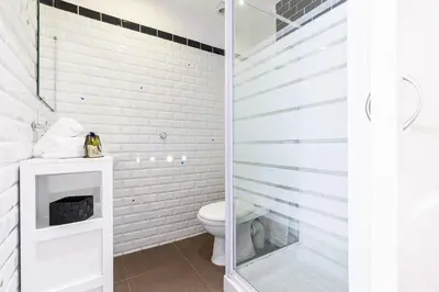 a bathroom with a toilet and a glass shower door at 1 Bdr Downtown near Place Massena in Nice