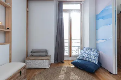 a bedroom with a blue couch and a window at 1 Bdr Downtown near Place Massena in Nice