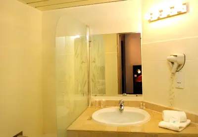 a bathroom with a sink and a mirror at Hôtel Du Baou in La Gaude