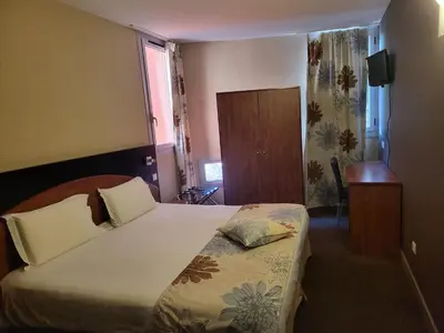 a hotel room with a bed and a window at Hôtel Du Baou in La Gaude