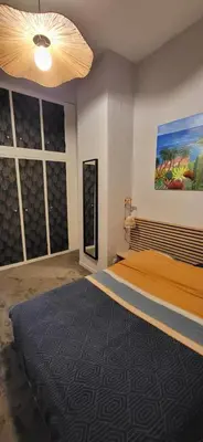 a bedroom with a bed and a painting on the wall at Au Coeur du vieux Nice in Nice