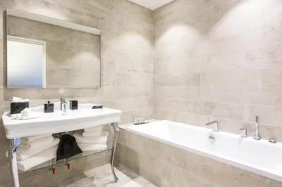 a bathroom with a sink and a tub and a mirror at Palais Saleya Boutique Hôtel in Nice