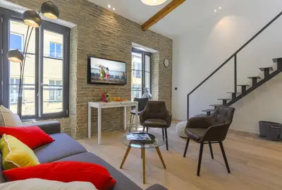 a living room with a couch and chairs and a staircase at MY CASA - 4 PLACE MASSENA - DUPLEX in Nice