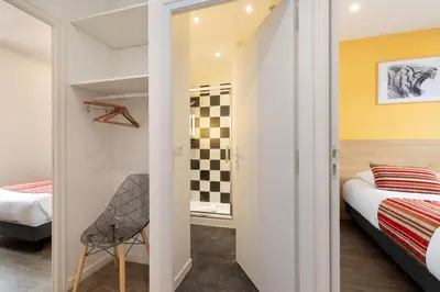 a small bedroom with a bed and a chair at Hôtel Byakko Nice in Nice