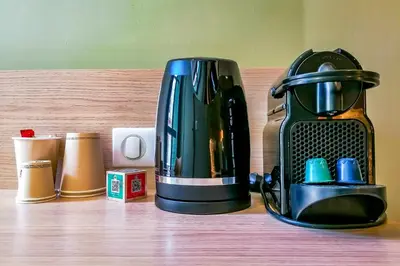 a coffee maker sitting on a wooden shelf at Hôtel Du Centre, un hôtel AMMI in Nice